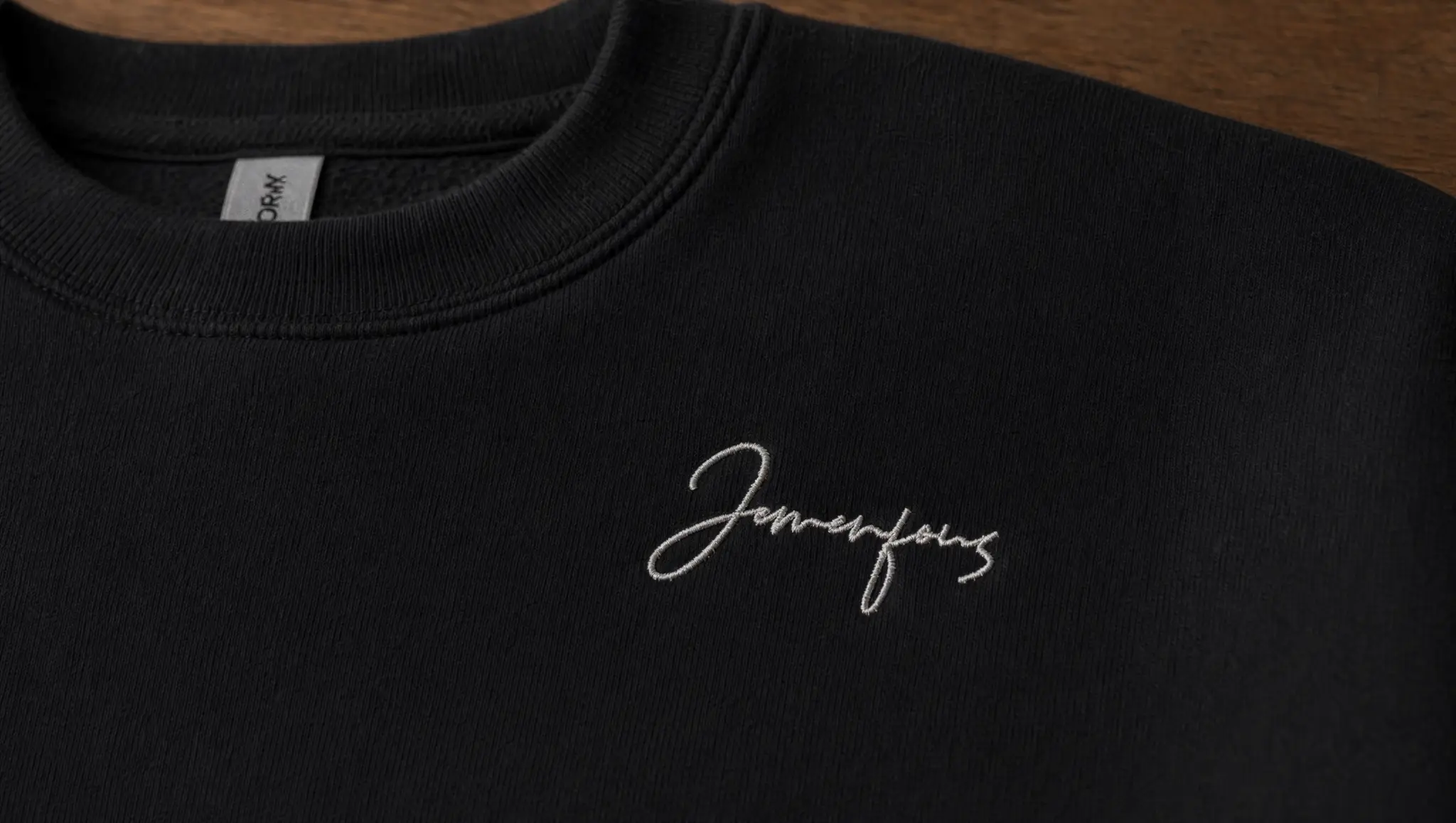 Broderie Jemenfous — signature cursive sur hoodie noir